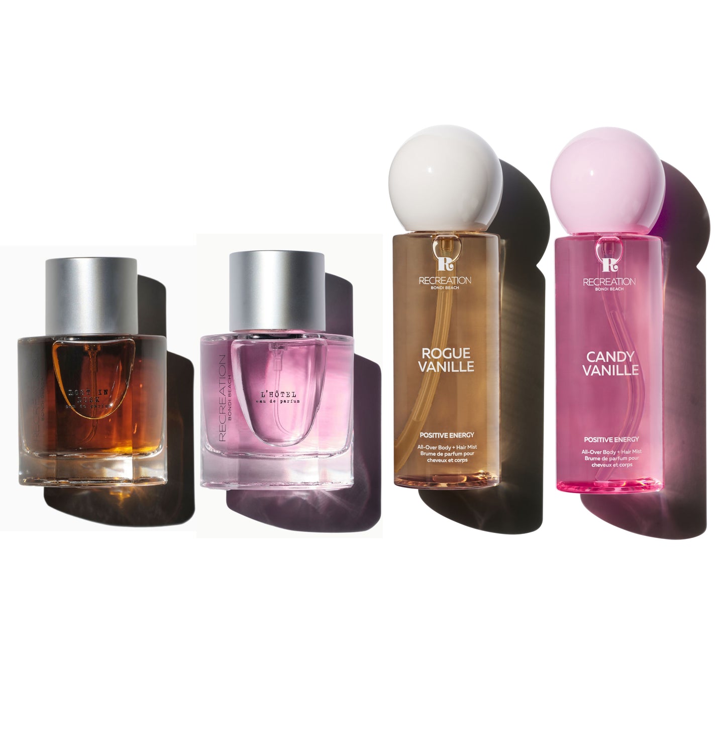 Two perfume bottles with silver caps placed beside two body mists, styled against a clean white background.