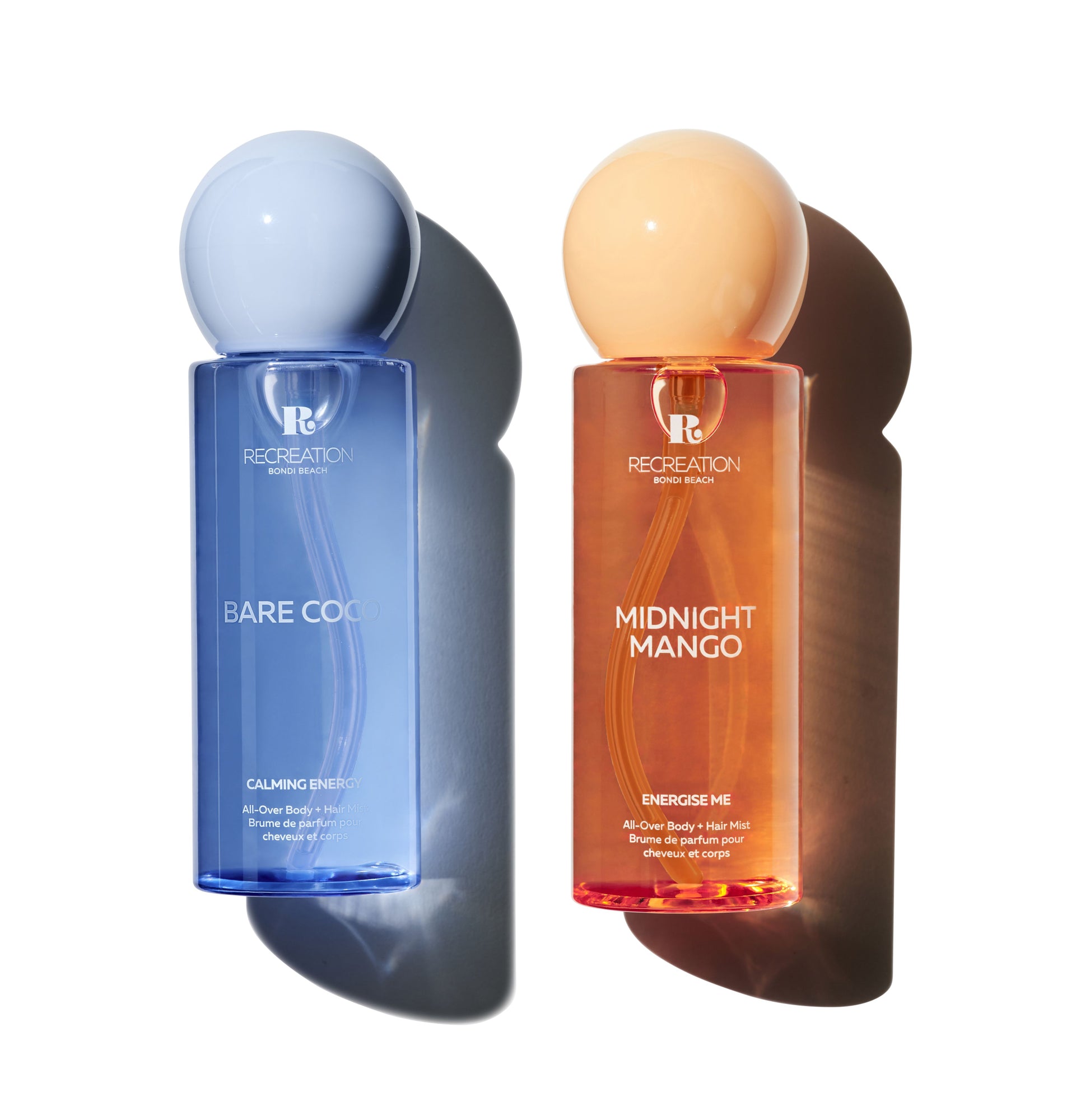 Two bottles of body mist products, one blue and one orange, on a white background.